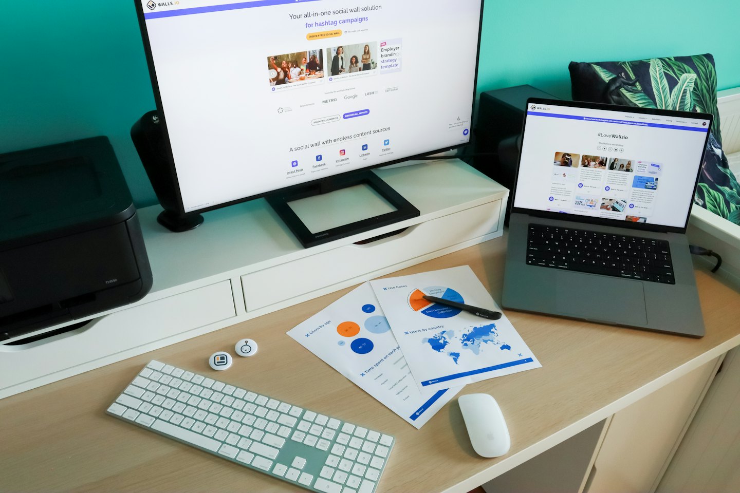 Monitörler, raporlar ve yazıcı bulunan ev ofis masası.